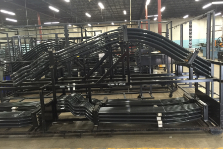 Finished black bent steel tube assemblies staged at Appian Manufacturing